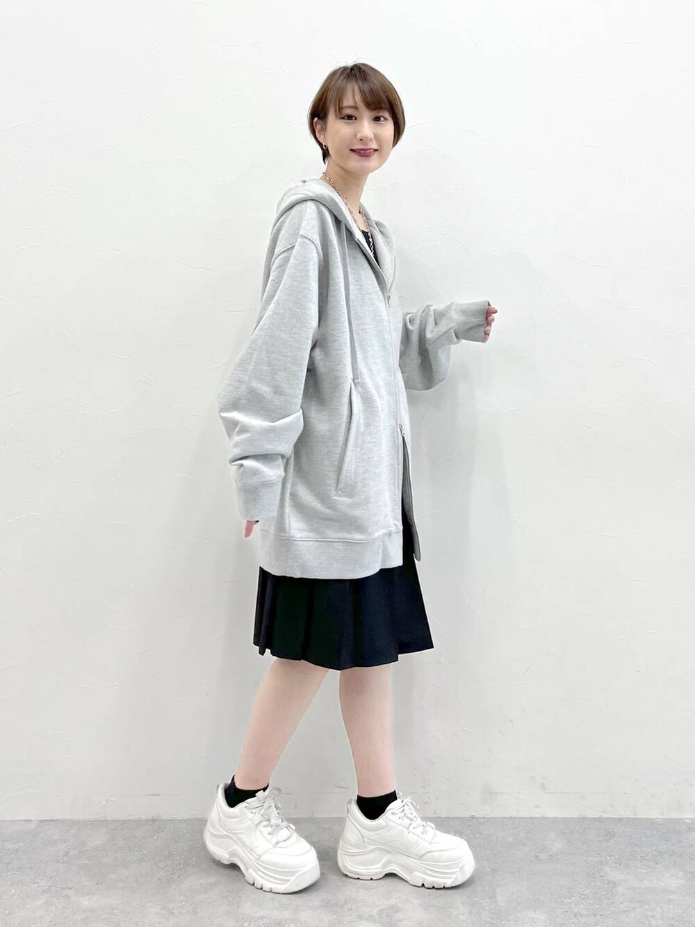グレー系のパーカー、ブラック系のスラックスを着用したレディースの春コーディネートの5枚目の写真