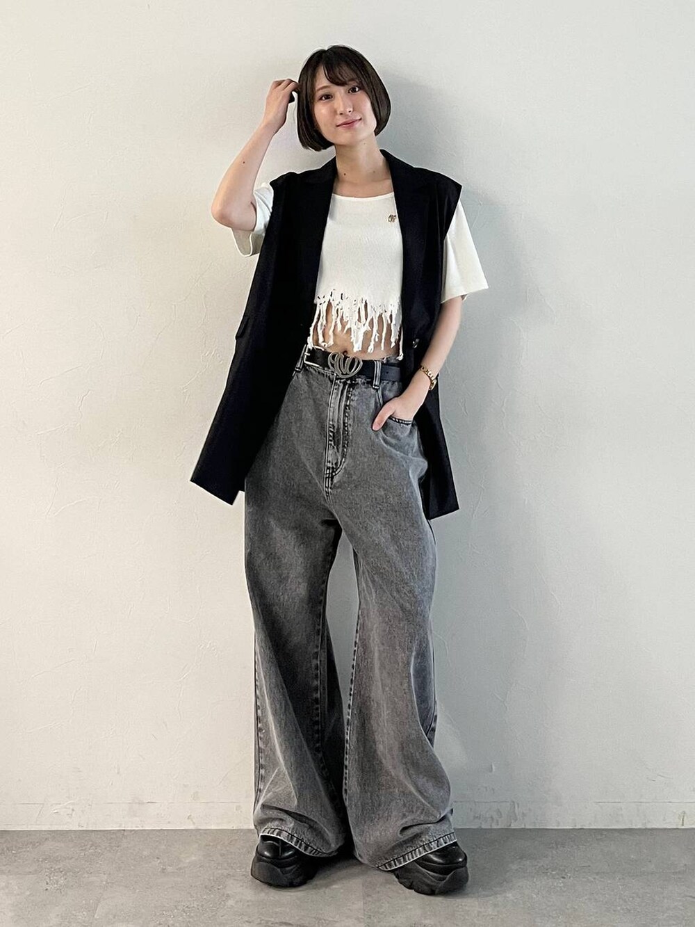 ブラック系のスニーカー、ブラック系のデニムパンツ、ブラック系のその他アウターを着用したレディースの春コーディネートの2枚目の写真