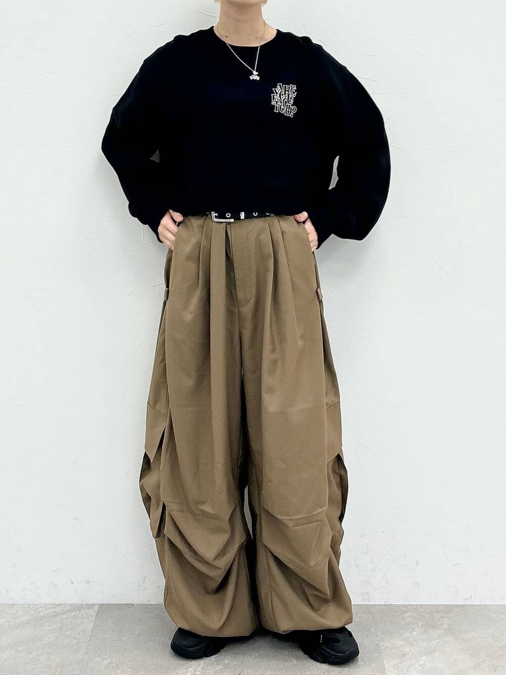 ブラック系のスウェット、ベージュ系のカーゴパンツ、シルバー系のネックレスを着用したレディースの秋コーディネートの2枚目の写真