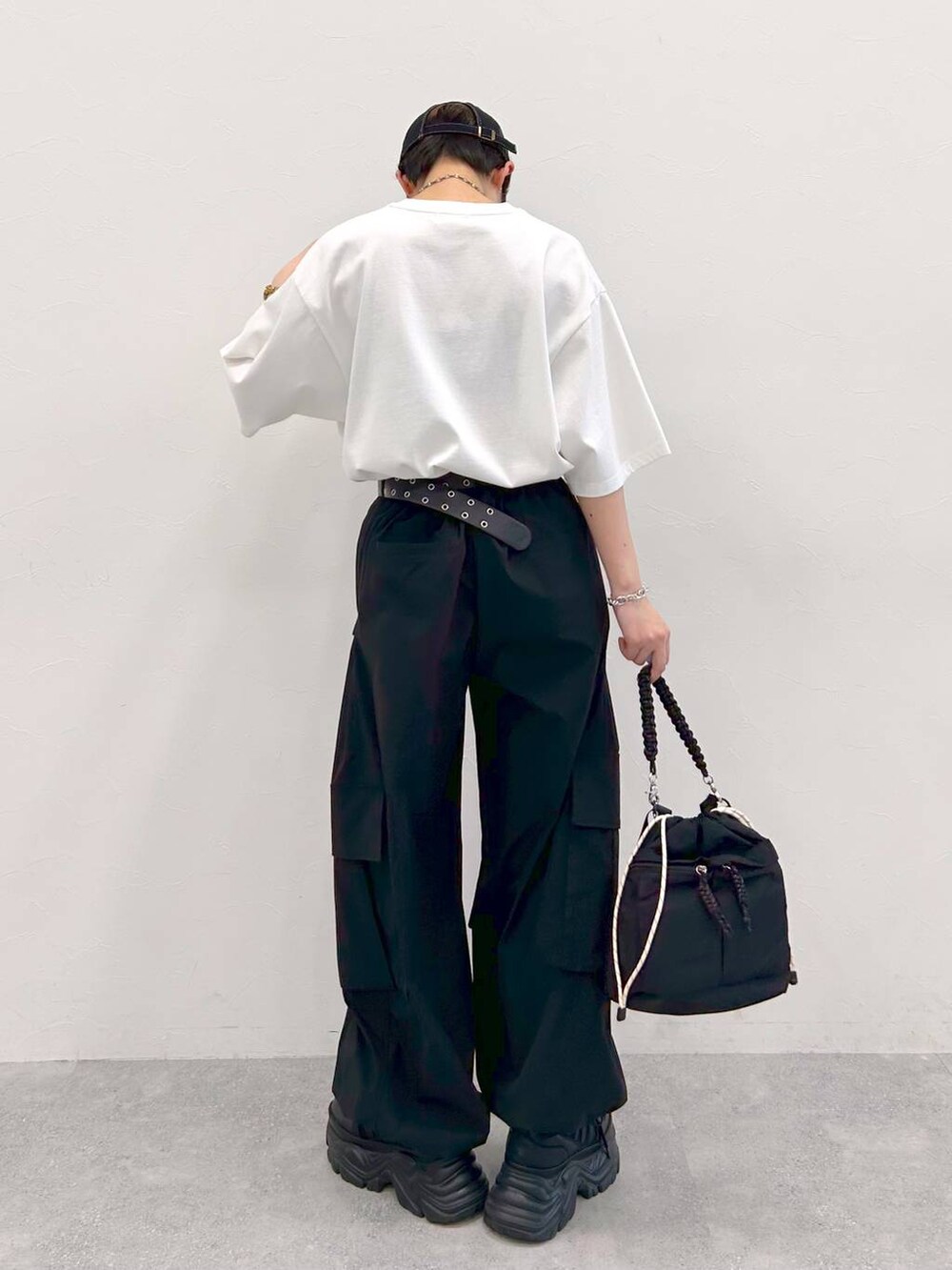 ブラック系のスニーカー、ホワイト系のTシャツ/カットソー、ブラック系のショルダーバッグを着用したレディースの夏コーディネートの7枚目の写真