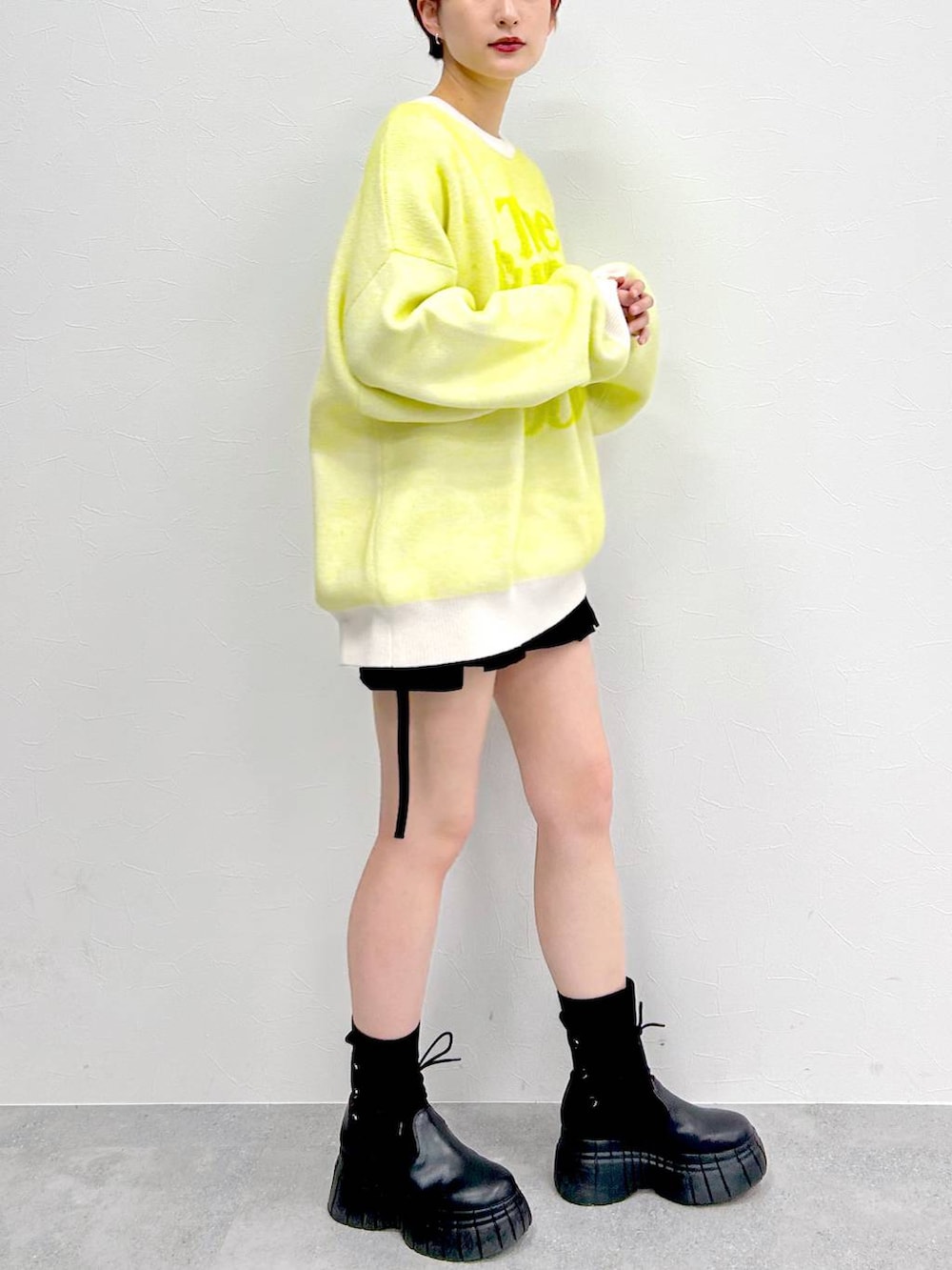 ホワイト系のニット/セーター、ブラック系のブーツ、ブラック系のスカートを着用したレディースの冬コーディネートの6枚目の写真