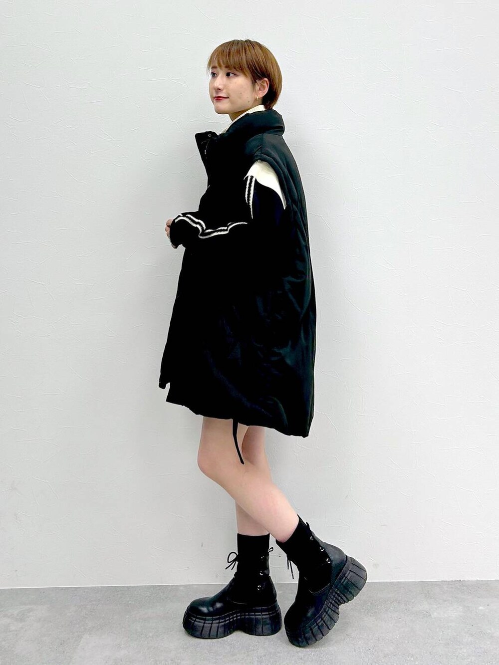 ブラック系のブルゾン、ブラック系のブーツ、ブラック系のスカートを着用したレディースの冬コーディネートの2枚目の写真