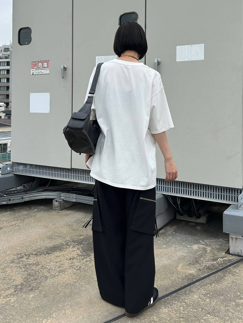 ブラック系のカーゴパンツ、ブラック系のショルダーバッグ、ホワイト系のTシャツ/カットソーを着用したレディースの夏コーディネートの6枚目の写真