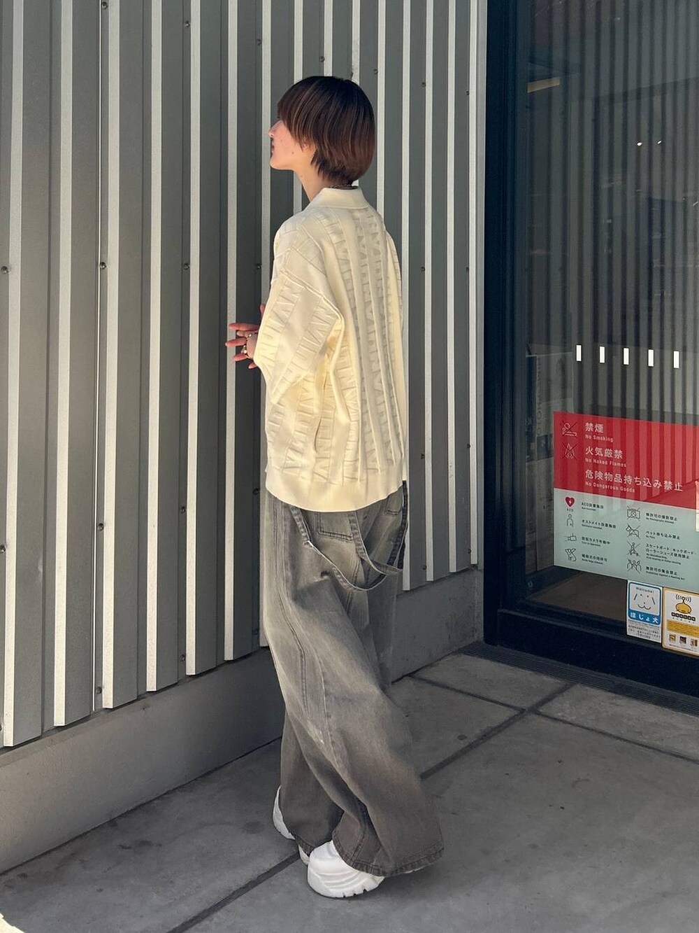 ブラック系のデニムパンツ、ホワイト系のニット/セーターを着用したレディースの春コーディネートの3枚目の写真