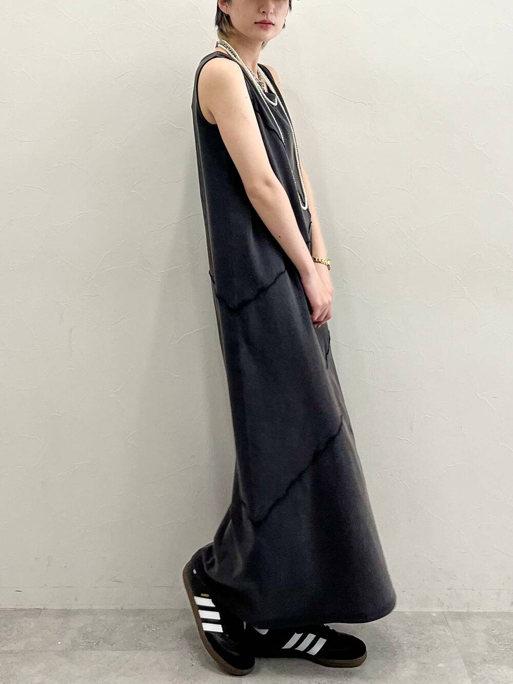 ブラック系のスニーカー、ブラック系のワンピース、ホワイト系のネックレスを着用したレディースの春コーディネートの7枚目の写真