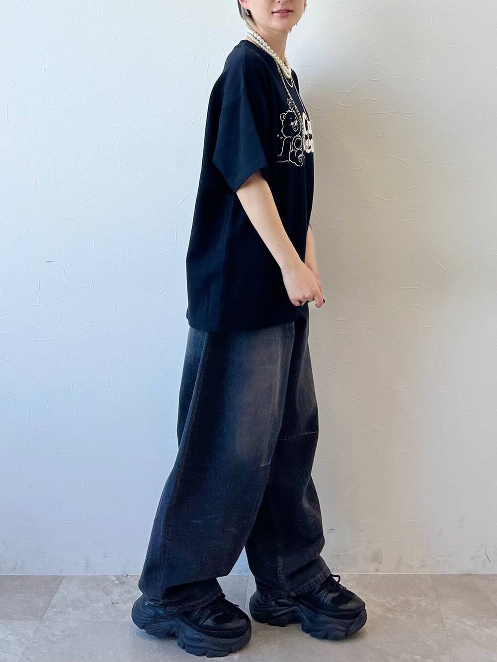 ブラック系のスニーカー、ブラック系のデニムパンツ、ブラック系のTシャツ/カットソーを着用したレディースの春コーディネートの4枚目の写真