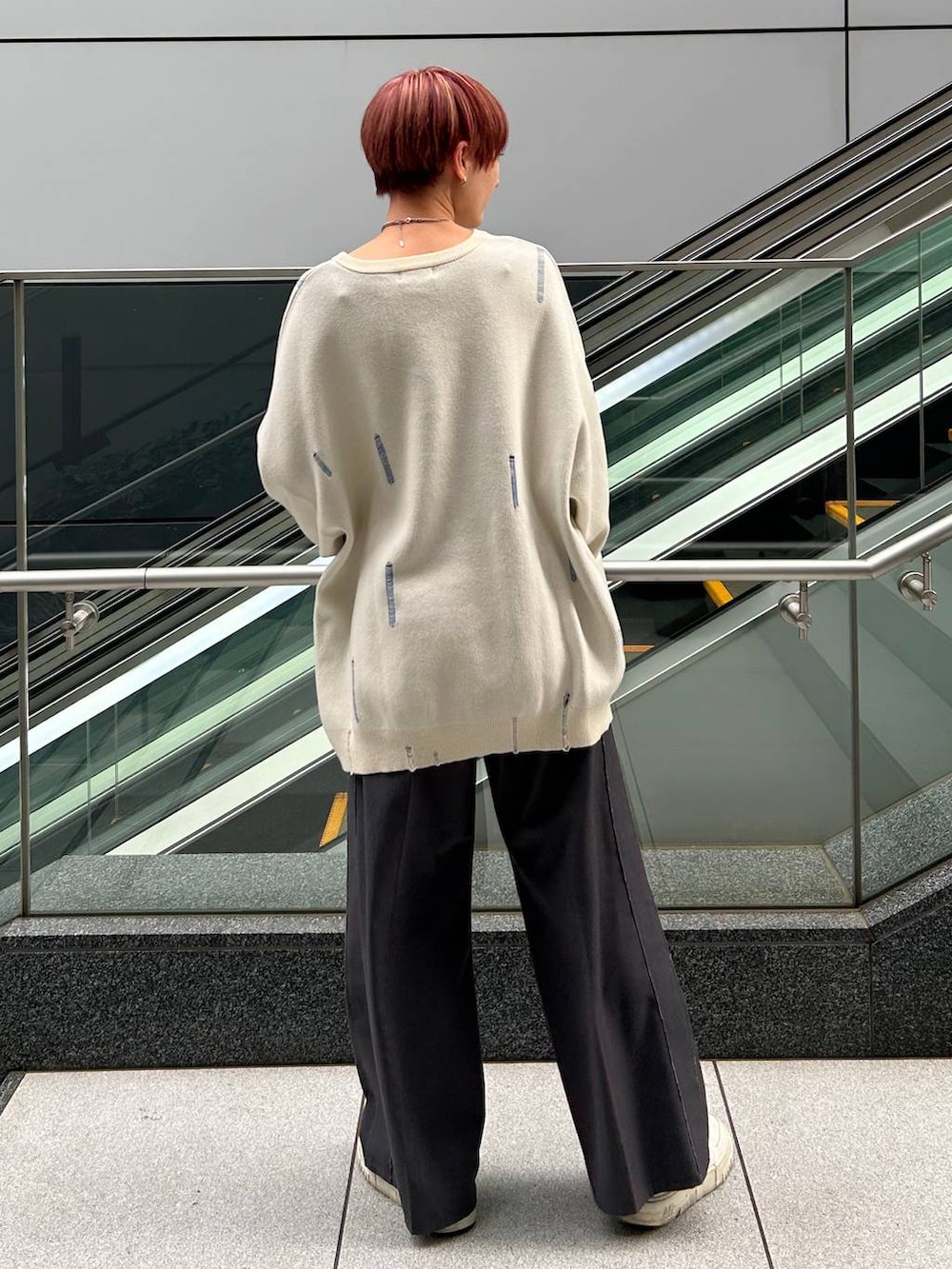 グレー系のスラックス、ホワイト系のニット/セーターを着用したレディースの冬コーディネートの5枚目の写真