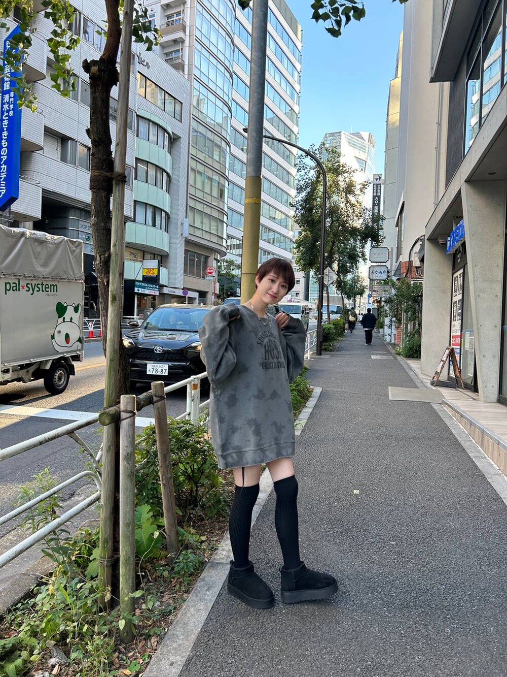 ブラック系のブーツ、ブラック系のスカート、グレー系のスウェットを着用したレディースの冬コーディネートの3枚目の写真