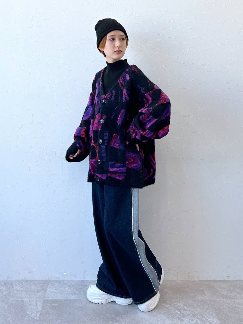 ブルー系のデニムパンツ、ブラック系のニット/セーター、ブラック系のニットキャップ/ビーニーを着用したレディースの秋コーディネートの4枚目の写真