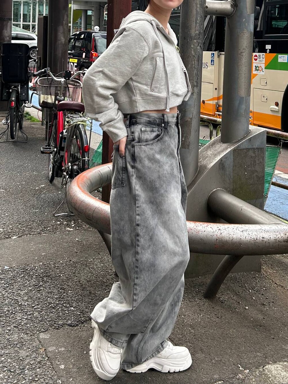 グレー系のパーカー、ブラック系のデニムパンツを着用したレディースの春コーディネートの3枚目の写真