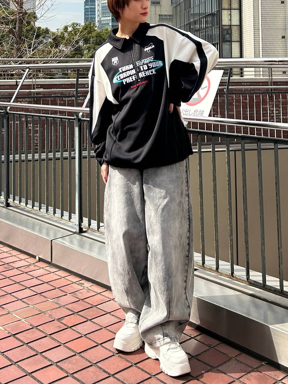 ブラック系のポロシャツ、ブラック系のデニムパンツを着用したレディースの春コーディネートの3枚目の写真