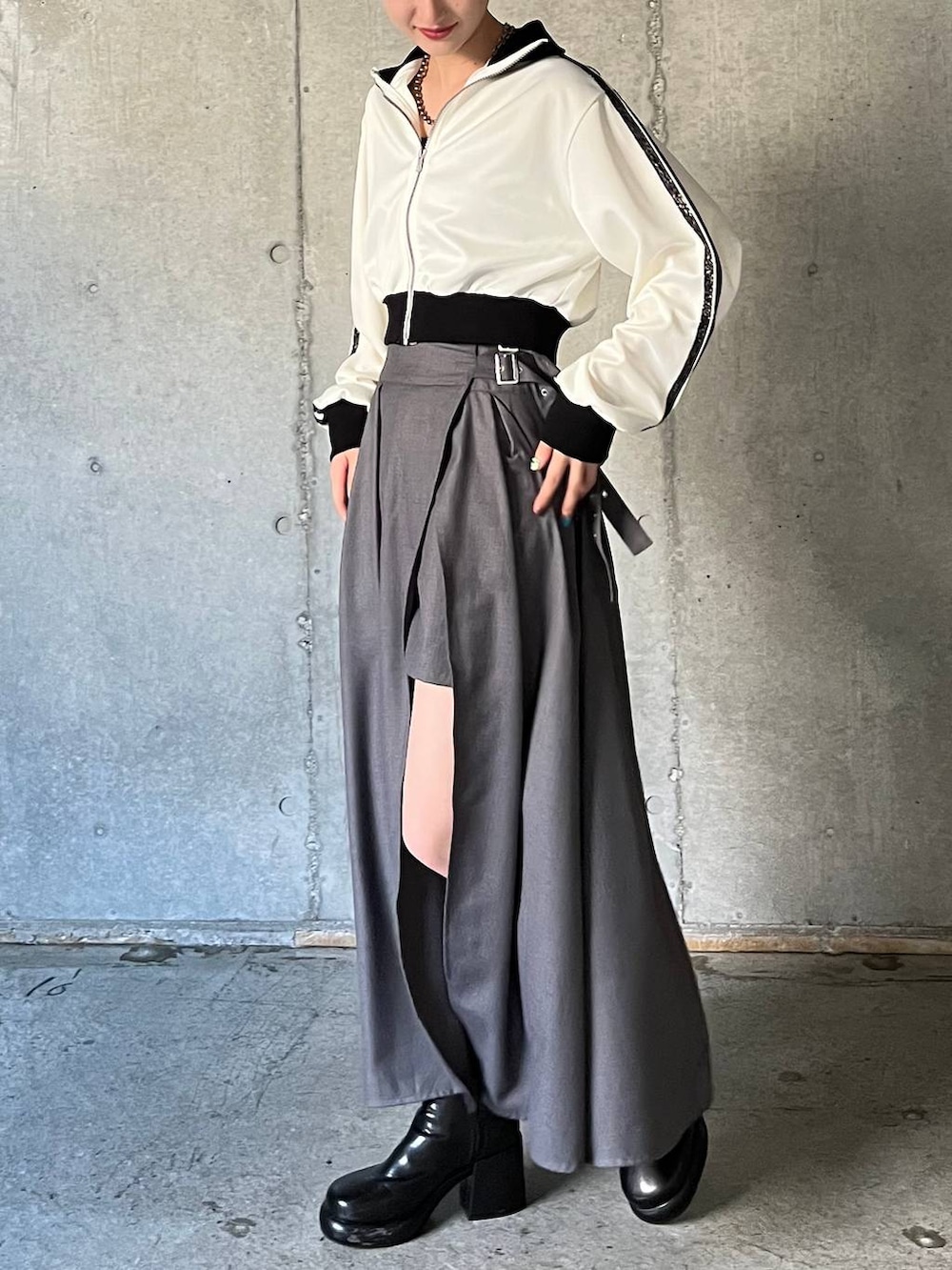 ブラック系のキャミソール、ブラック系のブーツ、グレー系のスカートを着用したレディースの冬コーディネートの3枚目の写真