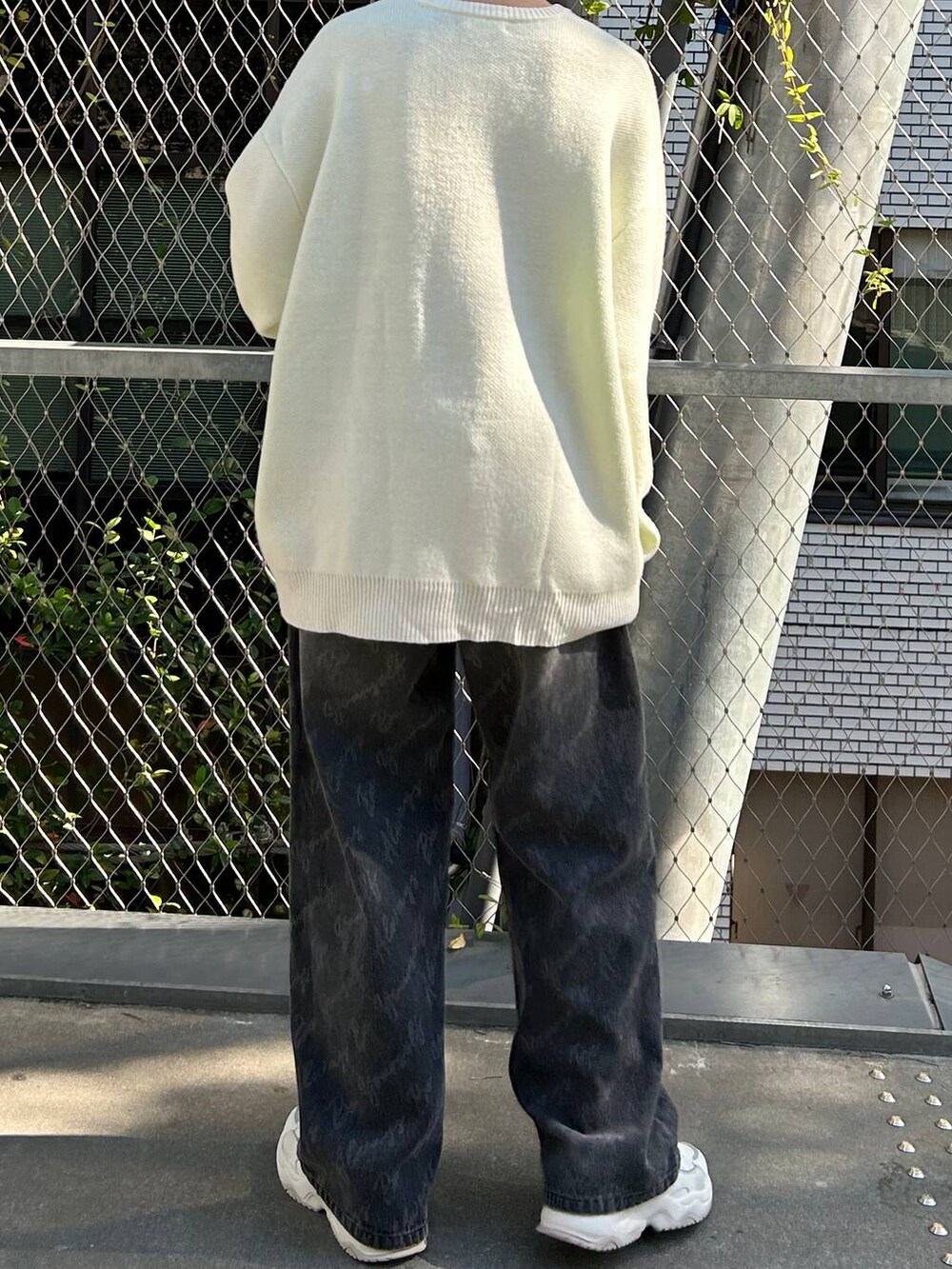 ブラック系のデニムパンツ、ホワイト系のニット/セーター、ブラック系のニットキャップ/ビーニーを着用したレディースの冬コーディネートの8枚目の写真