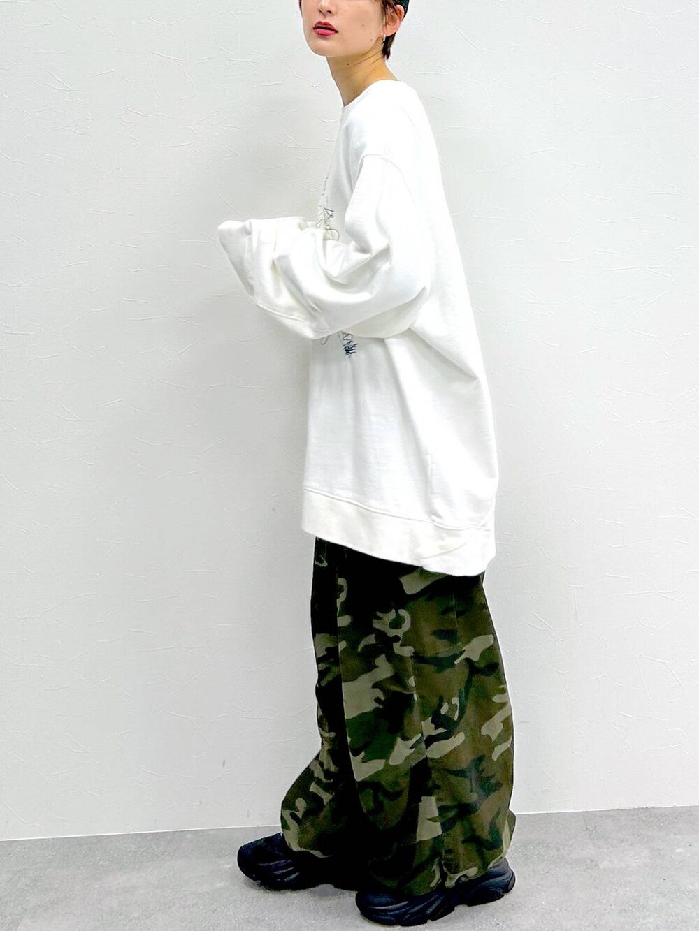 グリーン系のその他パンツ、ホワイト系のスウェット、ブラック系のキャップを着用したレディースの冬コーディネートの4枚目の写真