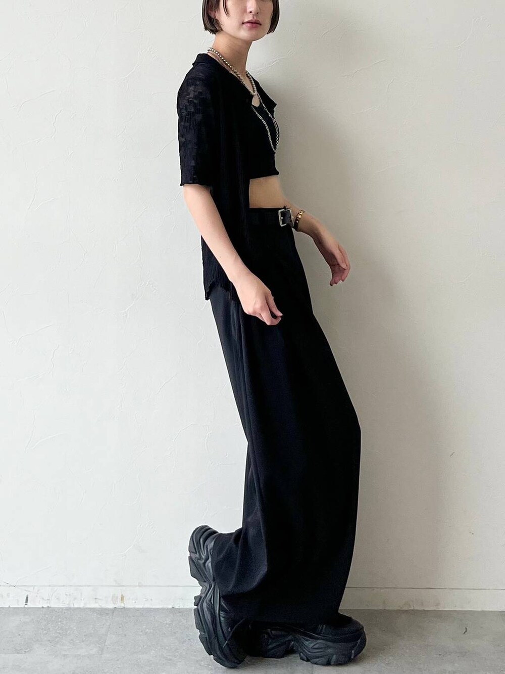 ブラック系のスニーカー、ブラック系のキャミソール、ブラック系のスラックスを着用したレディースの夏コーディネートの4枚目の写真