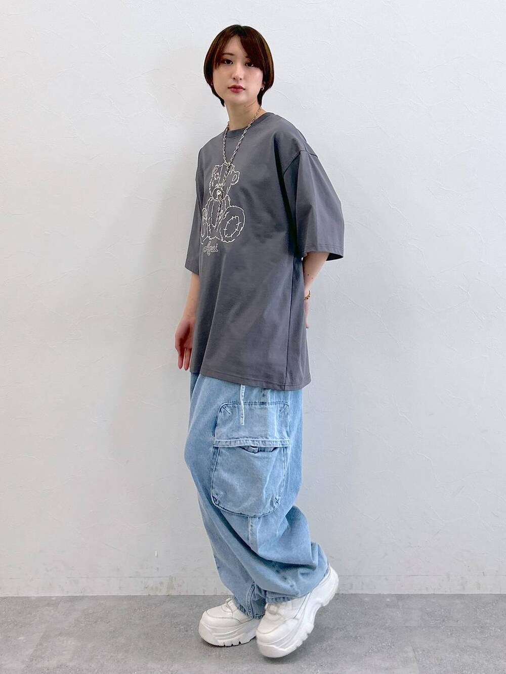 グレー系のTシャツ/カットソー、ブルー系のデニムパンツ、シルバー系のネックレスを着用したレディースの夏コーディネートの5枚目の写真