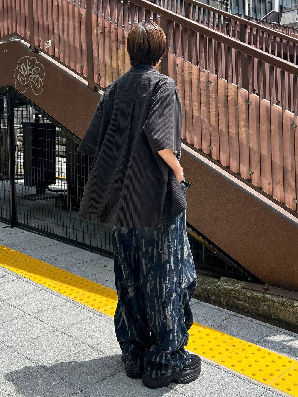 ブラック系のスニーカー、ホワイト系のTシャツ/カットソー、ブラック系のシャツ/ブラウスを着用したレディースの秋コーディネートの5枚目の写真