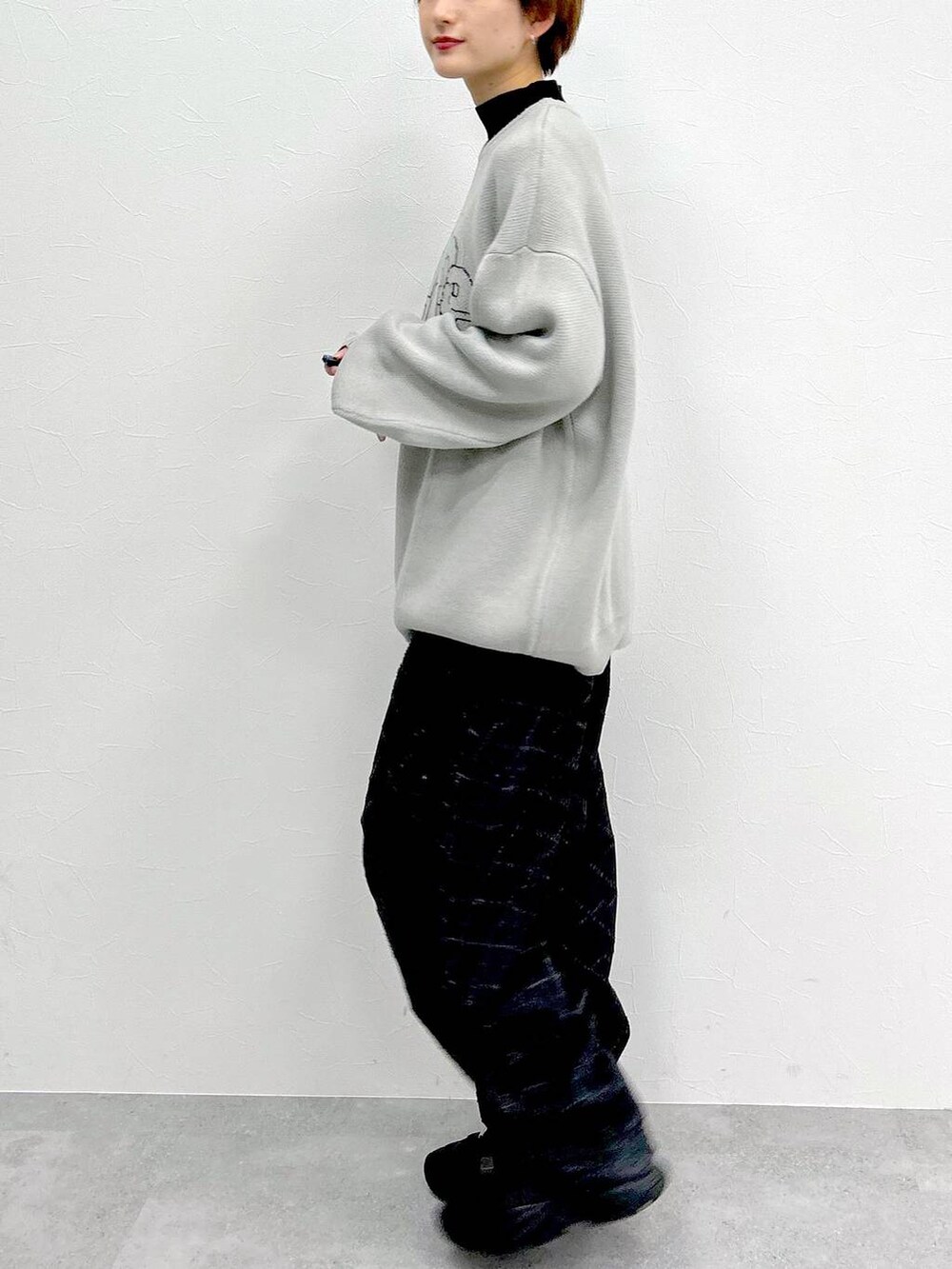 ブラック系のデニムパンツ、グレー系のニット/セーターを着用したレディースの冬コーディネートの4枚目の写真