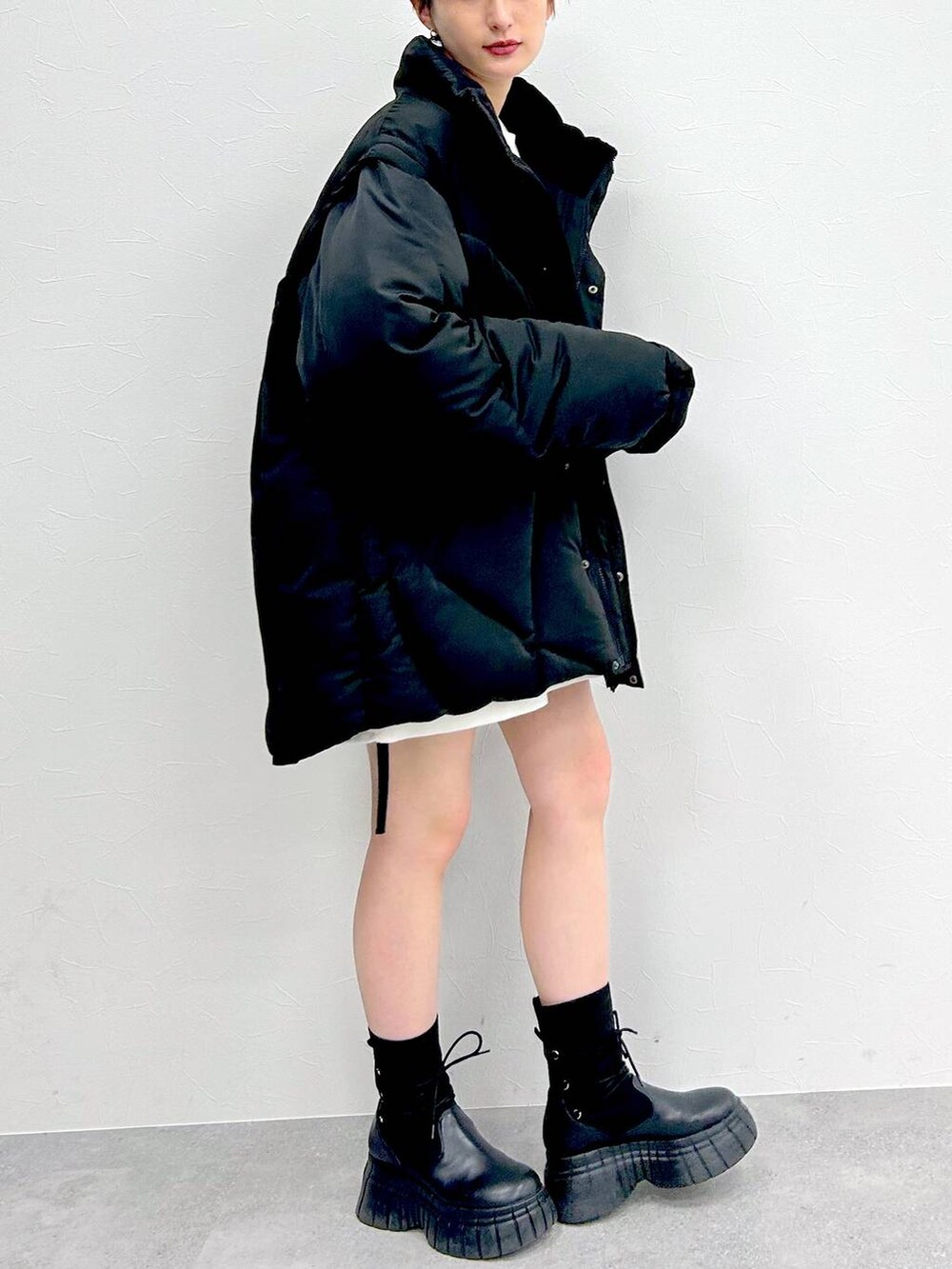 ブラック系のブルゾン、ブラック系のブーツ、ブラック系のスカートを着用したレディースの冬コーディネートの5枚目の写真