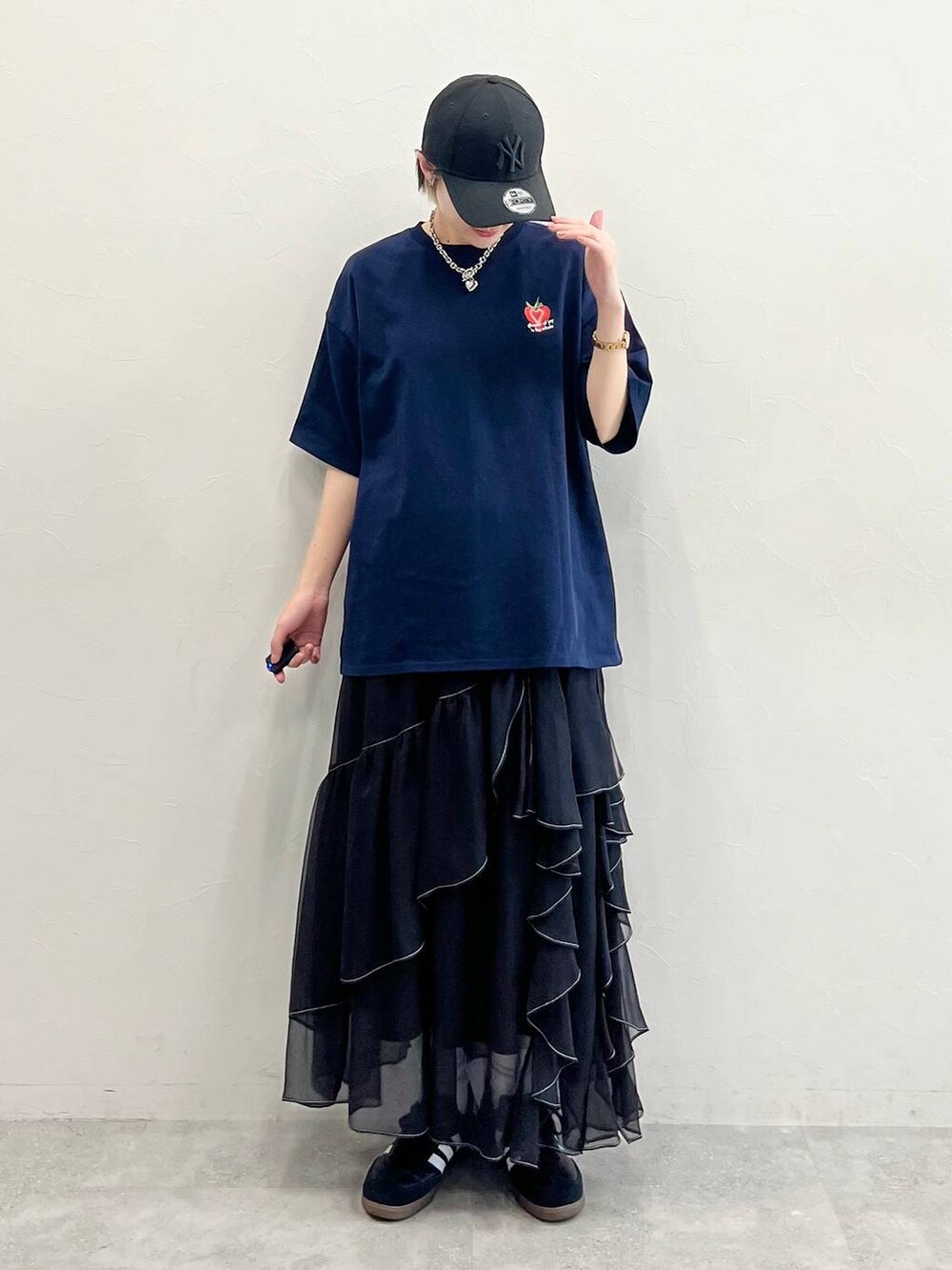 ブラック系のスカート、ブラック系のスニーカー、ブルー系のTシャツ/カットソーを着用したレディースの春コーディネートの3枚目の写真