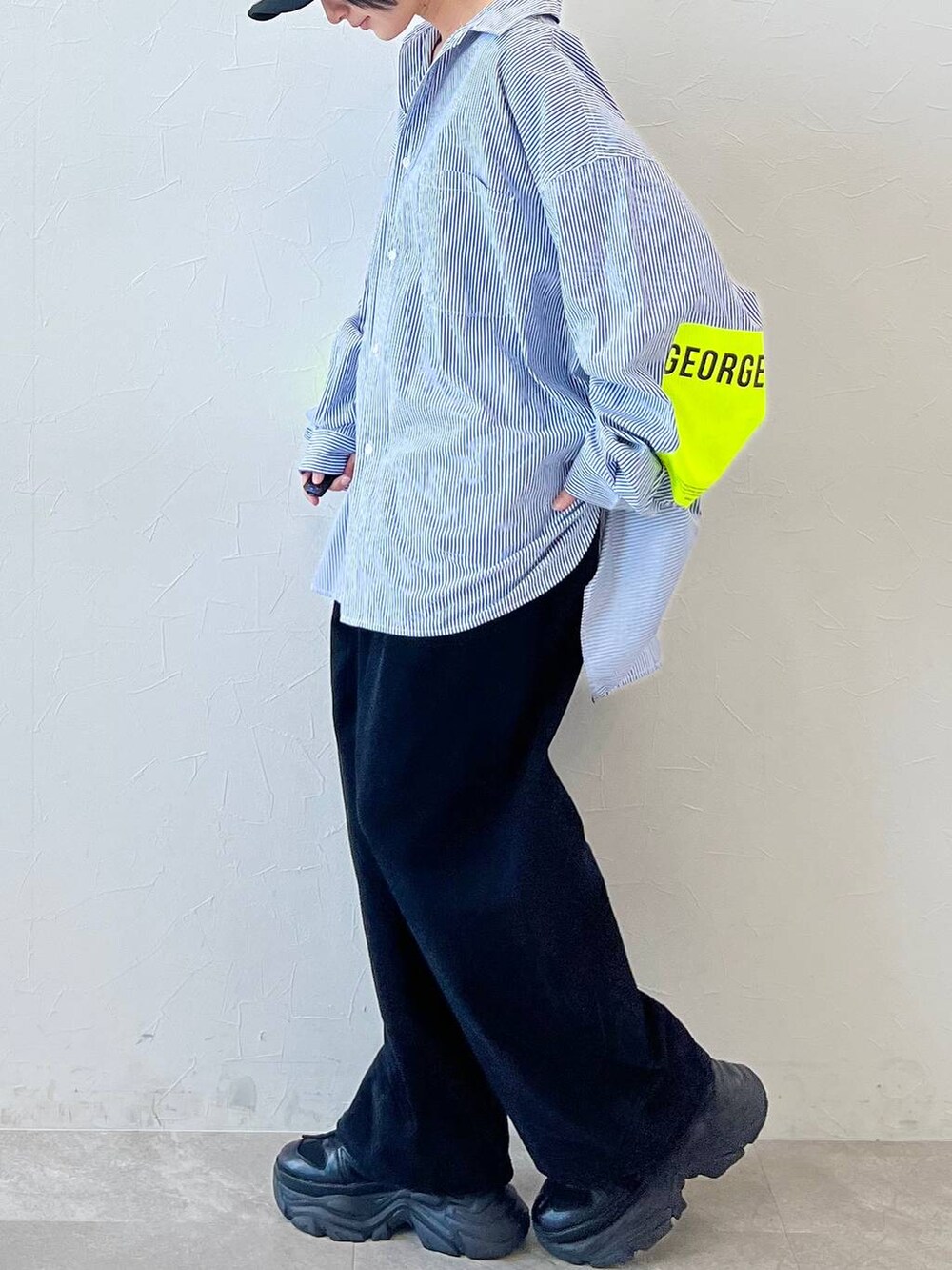 ブラック系のスニーカー、ブラック系のチノパンツ、ブラック系のキャップを着用したレディースの春コーディネートの2枚目の写真