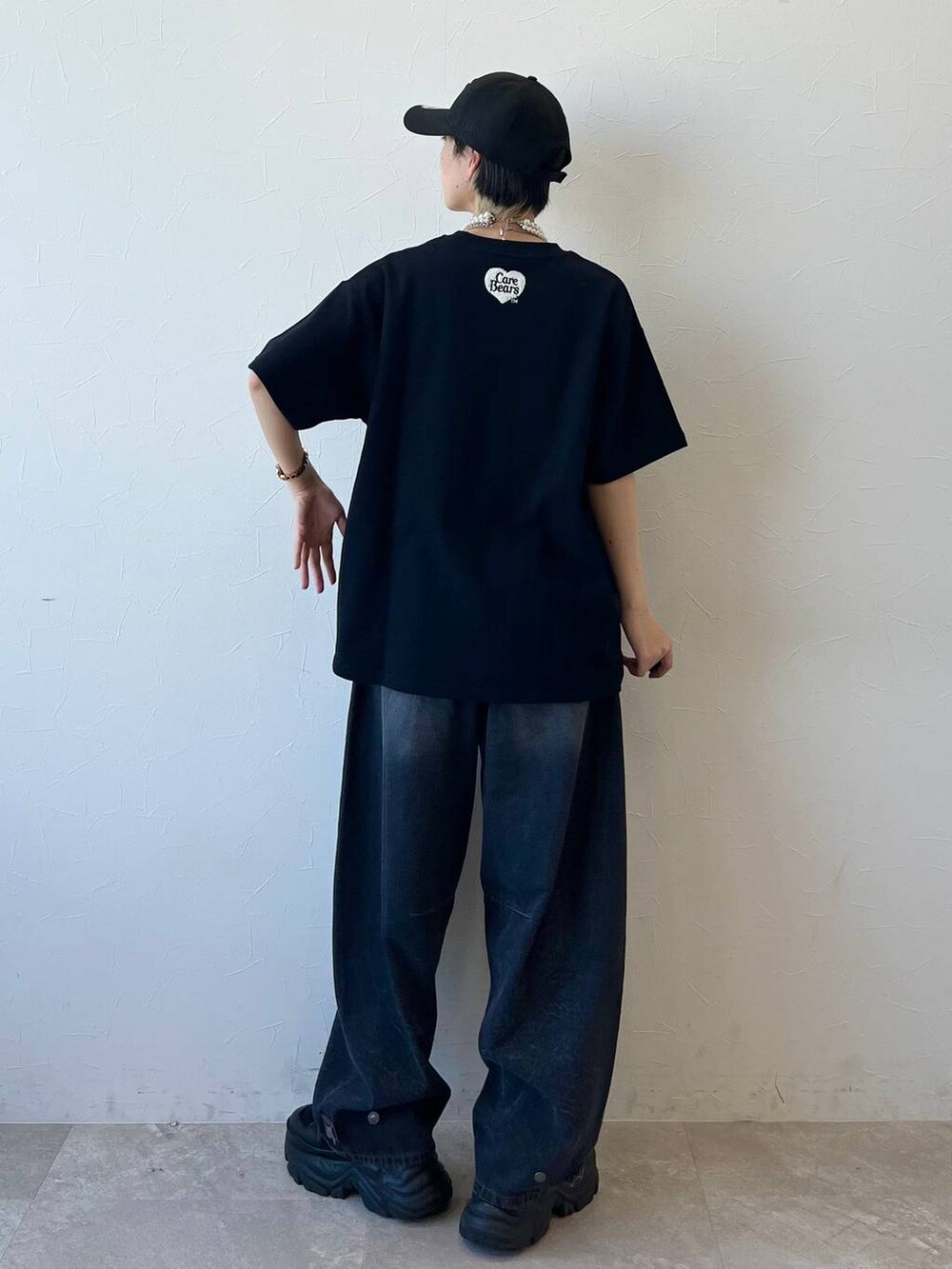 ブラック系のスニーカー、ブラック系のデニムパンツ、ブラック系のTシャツ/カットソーを着用したレディースの春コーディネートの7枚目の写真