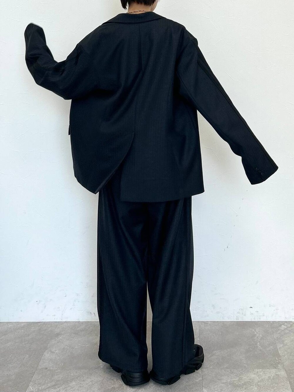 ブラック系のスラックス、ブラック系のテーラードジャケット、ブラック系のベルトを着用したレディースの秋コーディネートの7枚目の写真