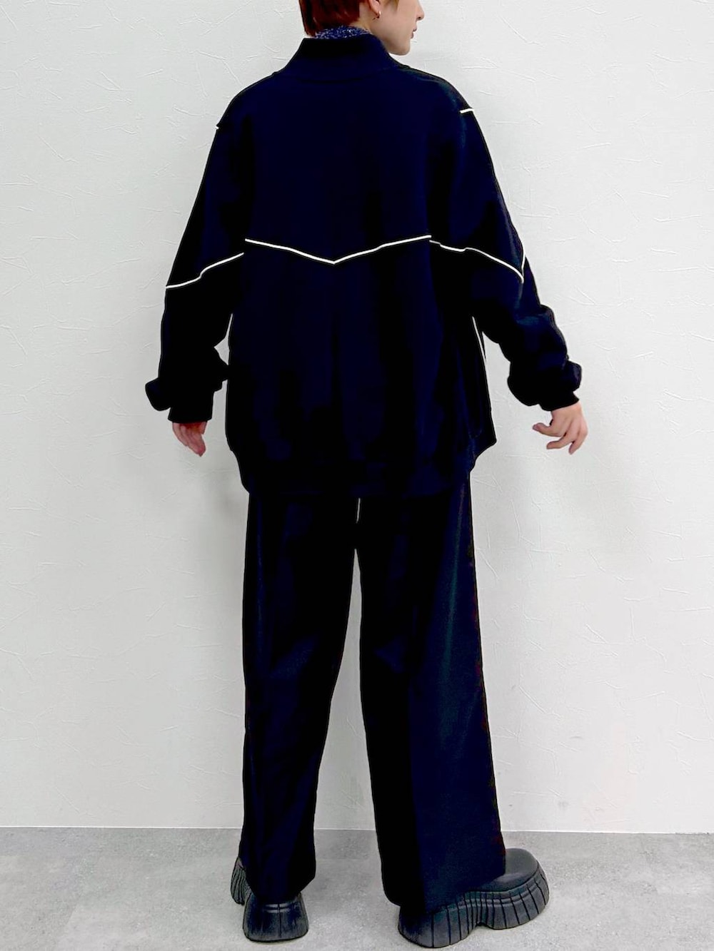 ブラック系のスウェット、ブラック系のブーツ、ブラック系のスラックスを着用したレディースの冬コーディネートの6枚目の写真