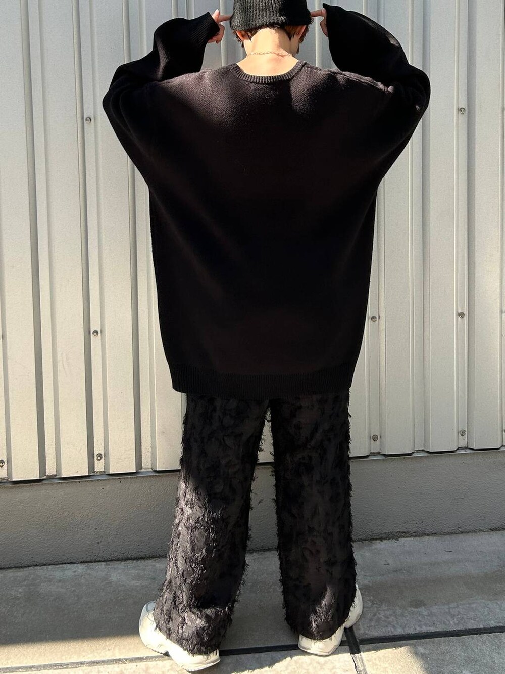 ブラック系のニット/セーター、ブラック系のスラックス、ブラック系のニットキャップ/ビーニーを着用したレディースの冬コーディネートの8枚目の写真