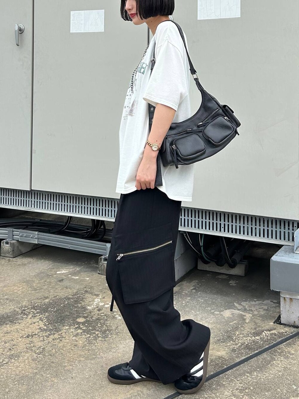 ブラック系のカーゴパンツ、ブラック系のショルダーバッグ、ホワイト系のTシャツ/カットソーを着用したレディースの夏コーディネートの5枚目の写真