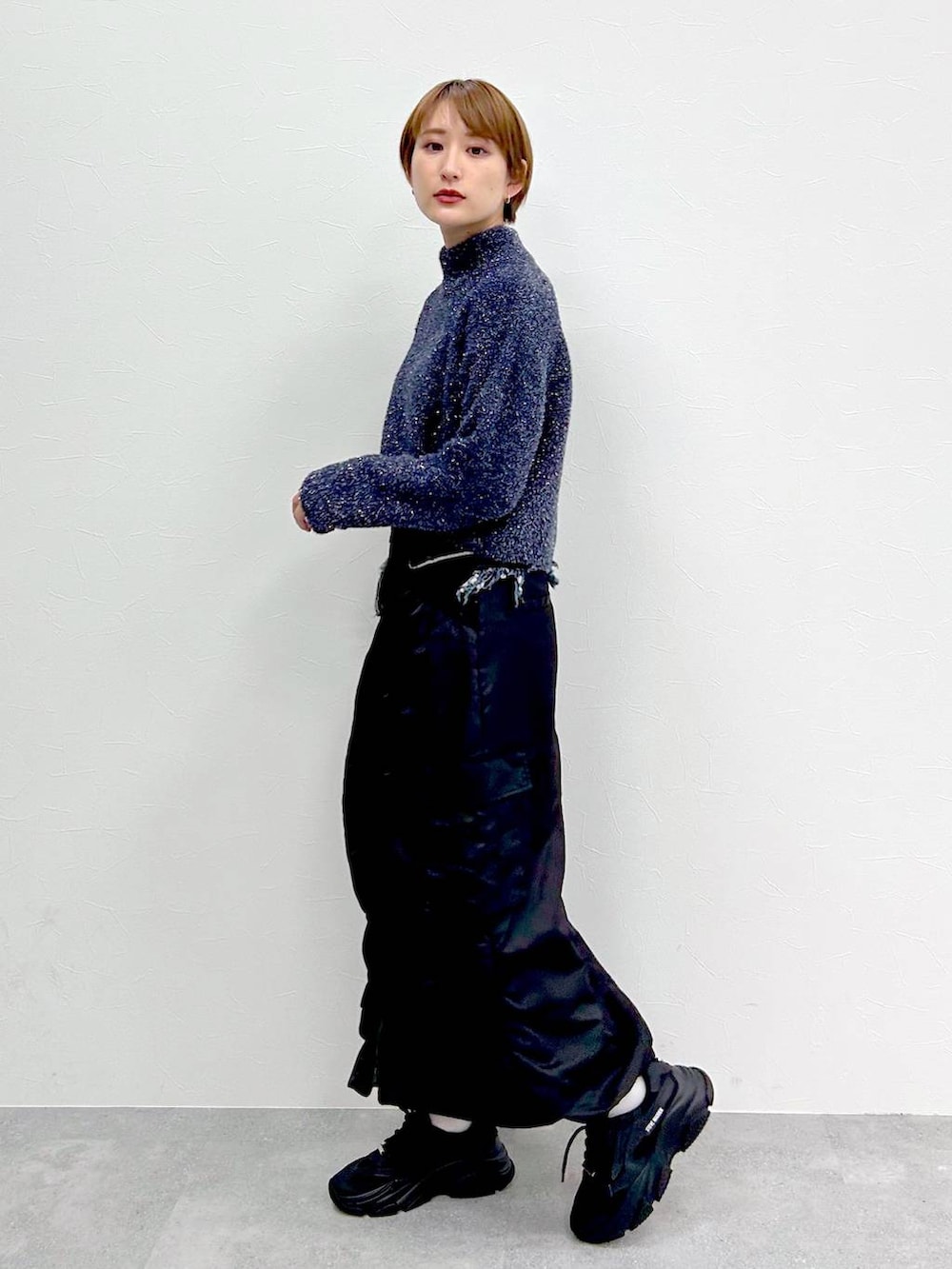 ブルー系のニット/セーター、ブラック系のスカートを着用したレディースの冬コーディネートの3枚目の写真