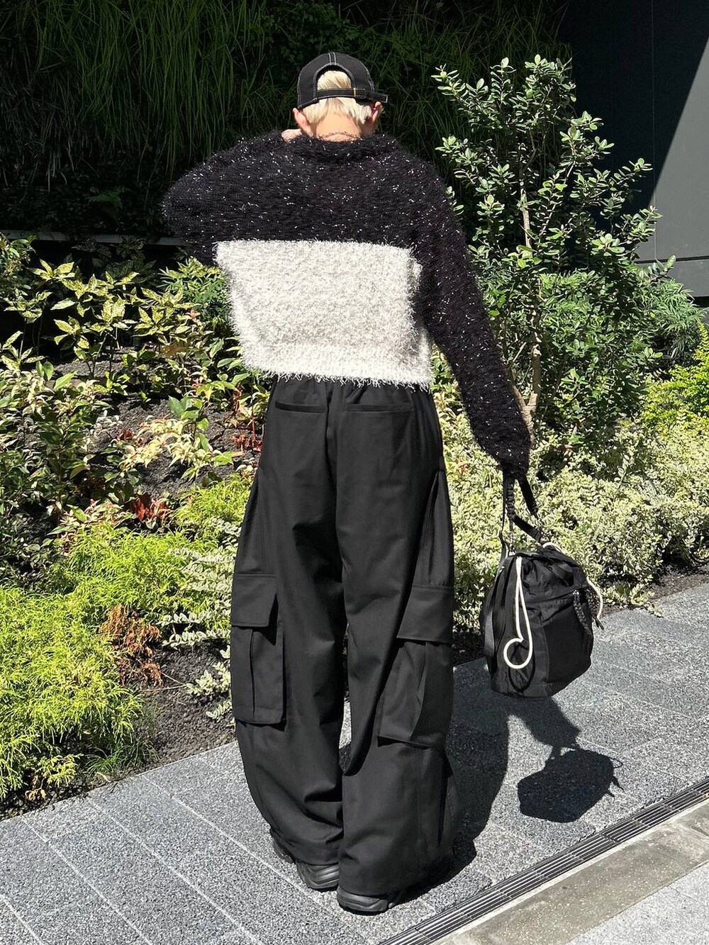 ブラック系のショルダーバッグ、ブラック系のスニーカー、ホワイト系のニット/セーターを着用したレディースの秋コーディネートの7枚目の写真