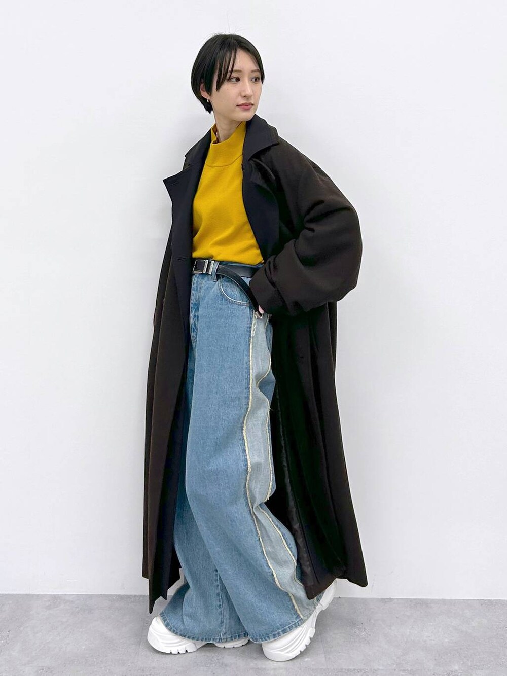 イエロー系のニット/セーター、ブルー系のデニムパンツ、ブラウン系のその他アウターを着用したレディースの秋コーディネートの3枚目の写真