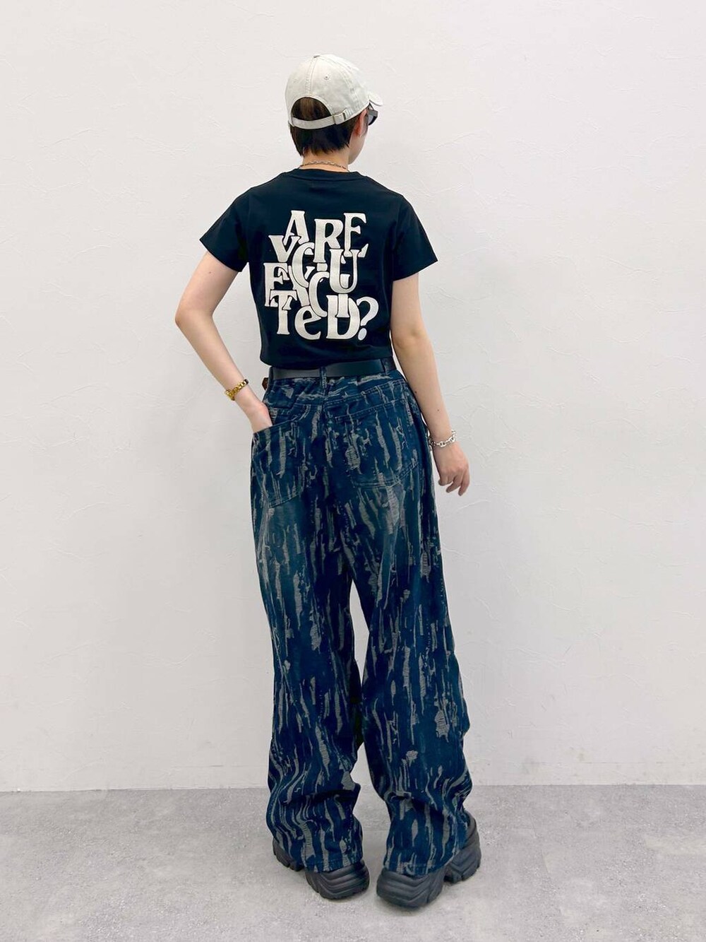 ブラック系のスニーカー、ブラック系のTシャツ/カットソー、ブルー系のデニムパンツを着用したレディースの夏コーディネートの8枚目の写真