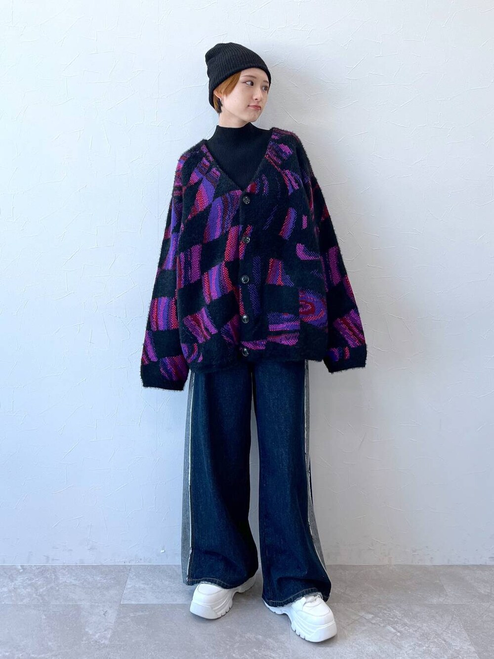 ブルー系のデニムパンツ、ブラック系のニット/セーター、ブラック系のニットキャップ/ビーニーを着用したレディースの秋コーディネートの2枚目の写真