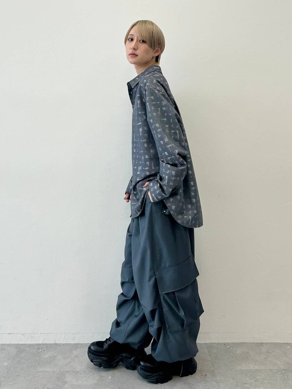 ブラック系のブーツ、ブラック系のシャツ/ブラウス、グレー系のカーゴパンツを着用したレディースの秋コーディネートの3枚目の写真