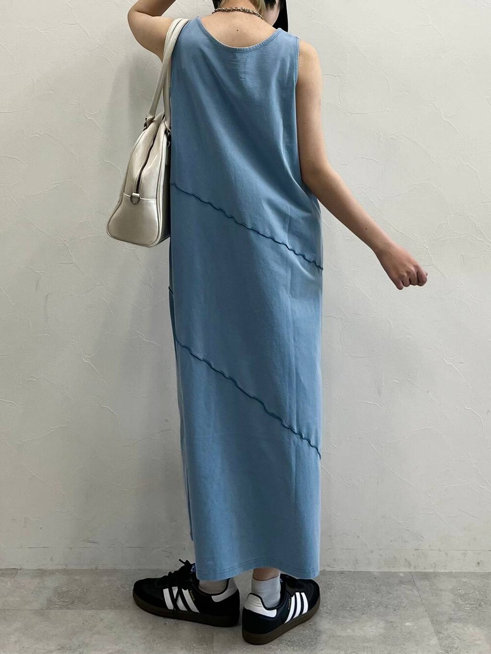 ホワイト系のボストンバッグ、ブラック系のスニーカー、ブルー系のワンピースを着用したレディースの春コーディネートの7枚目の写真