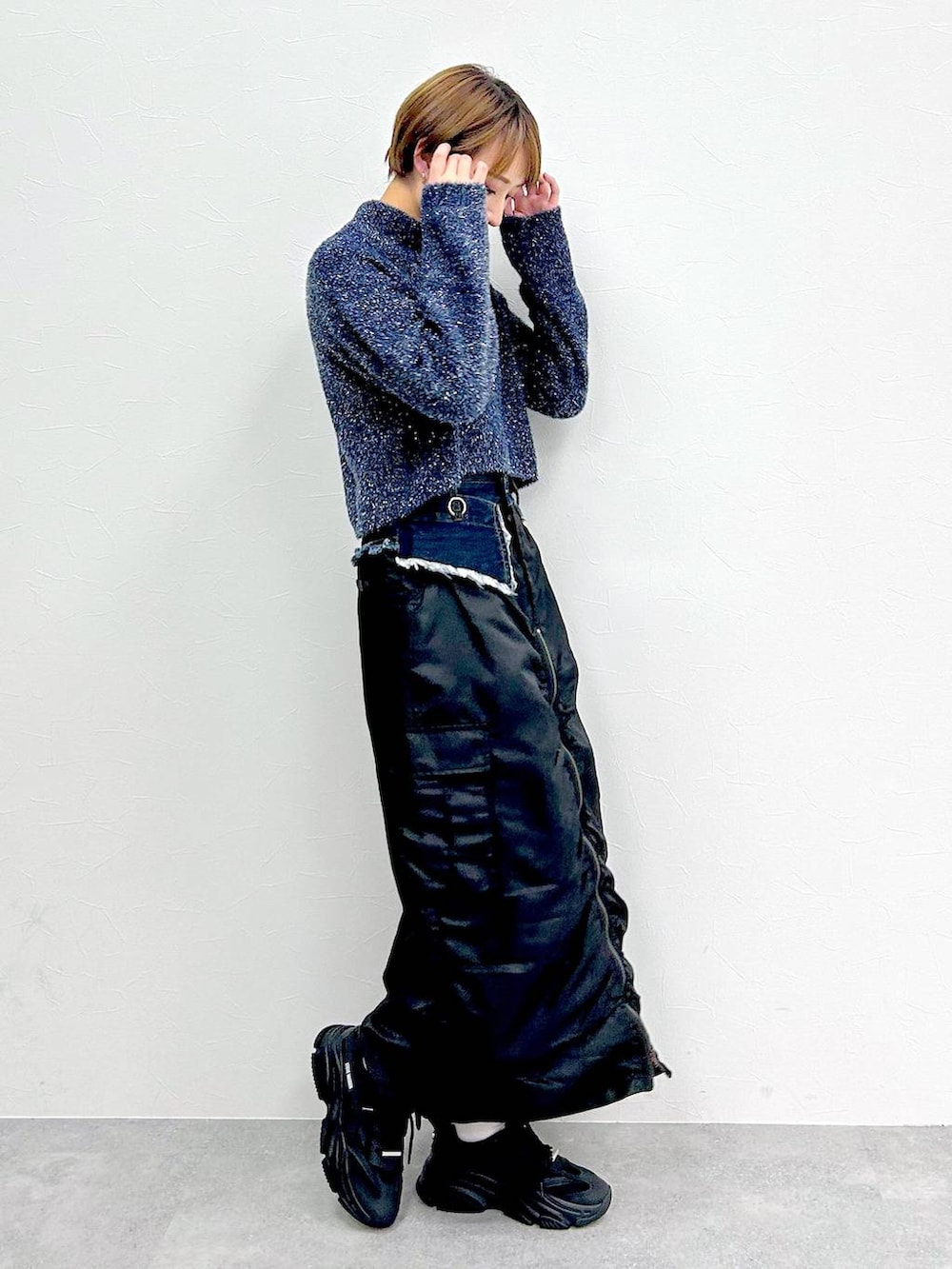 ブルー系のニット/セーター、ブラック系のスカートを着用したレディースの冬コーディネートの5枚目の写真