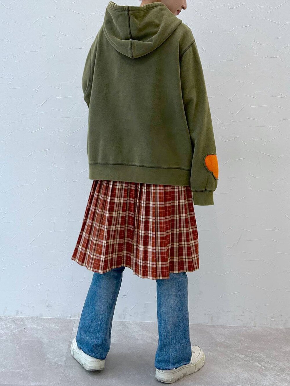 グリーン系のパーカー、レッド系のスカートを着用したレディースの秋コーディネートの6枚目の写真