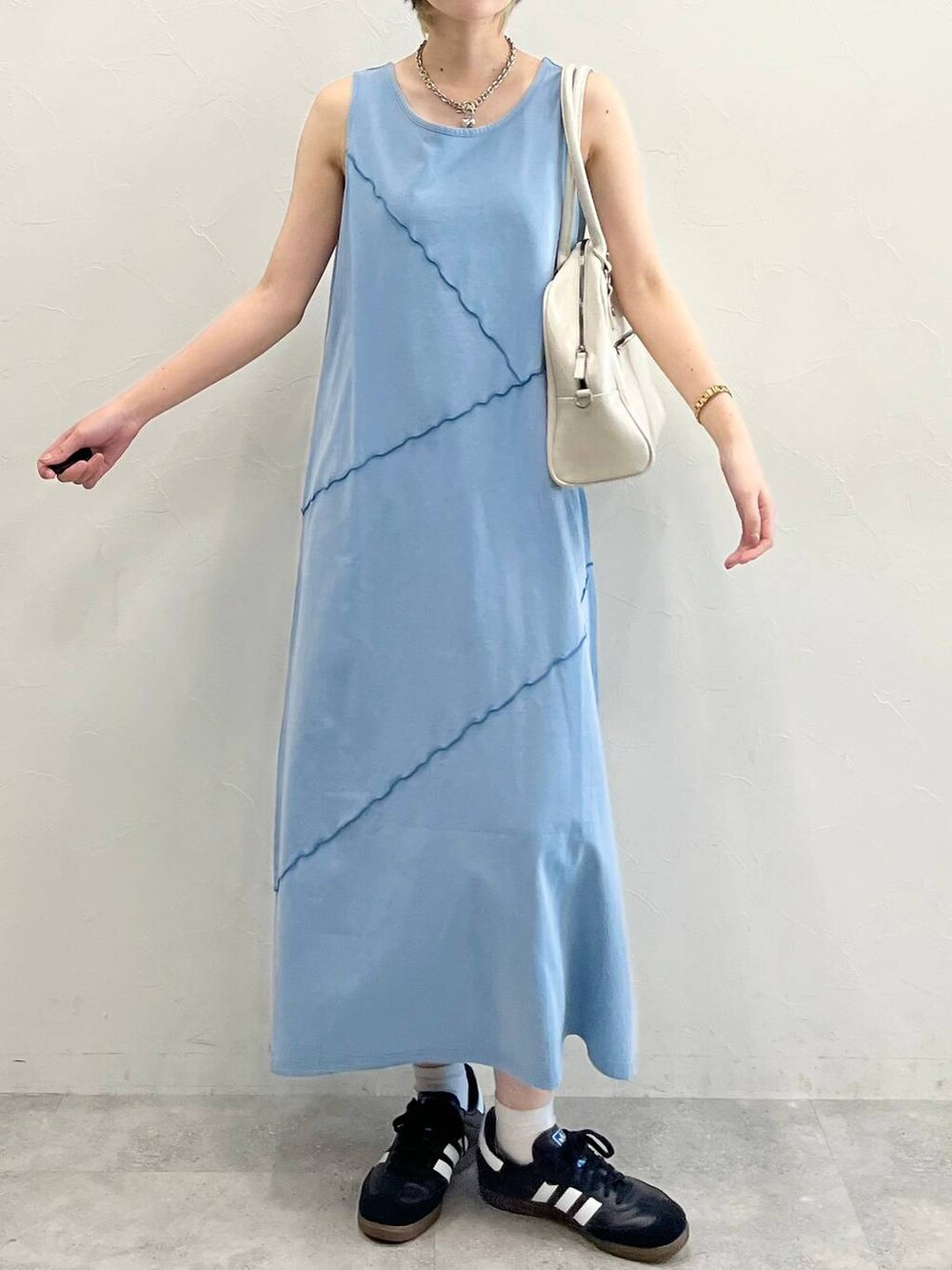 ホワイト系のボストンバッグ、ブラック系のスニーカー、ブルー系のワンピースを着用したレディースの春コーディネートの2枚目の写真