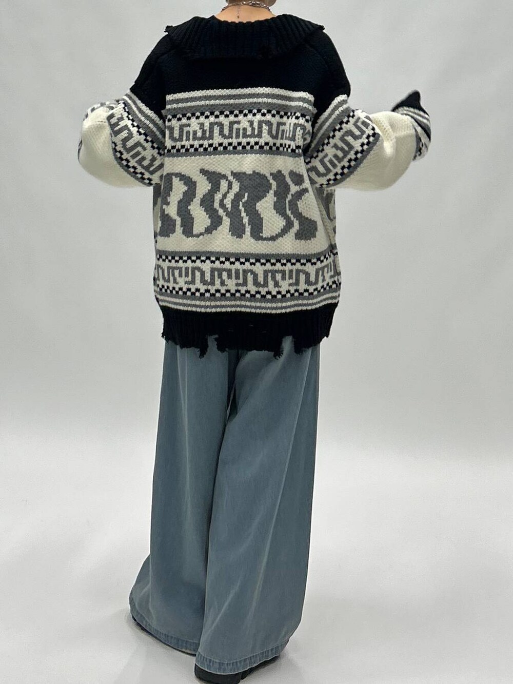 ブルー系のデニムパンツ、ブラック系のブーツ、ブラック系のスウェットを着用したレディースの秋コーディネートの6枚目の写真