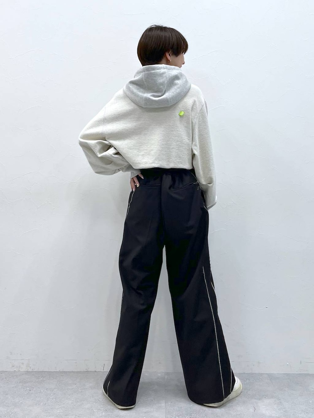 ブラック系のスラックス、グレー系のパーカーを着用したレディースの秋コーディネートの7枚目の写真