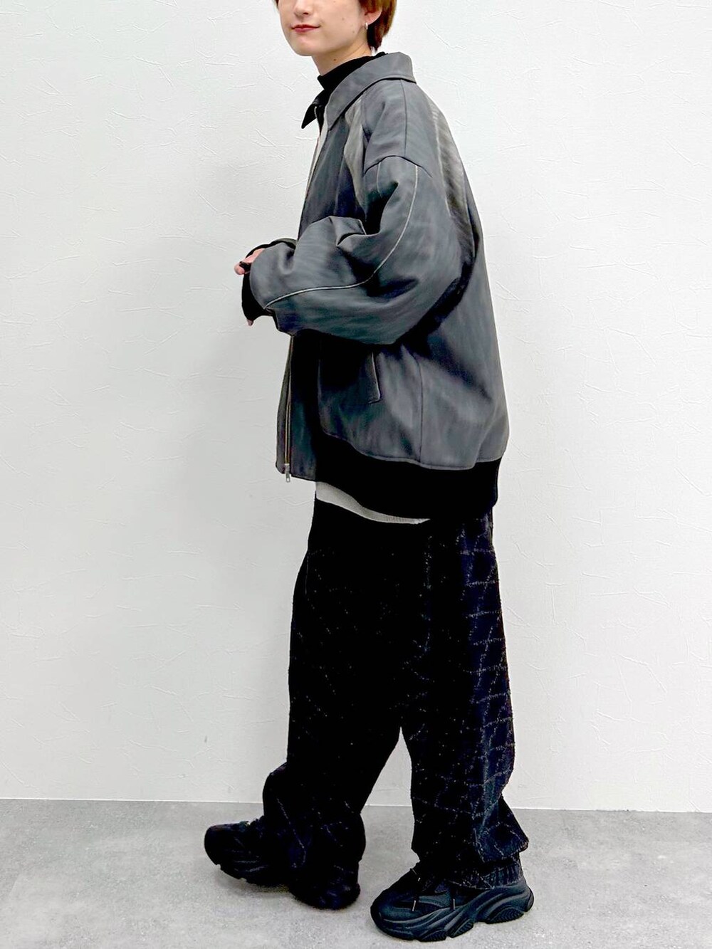 グレー系のブルゾン、ブラック系のデニムパンツ、グレー系のニット/セーターを着用したレディースの春コーディネートの6枚目の写真