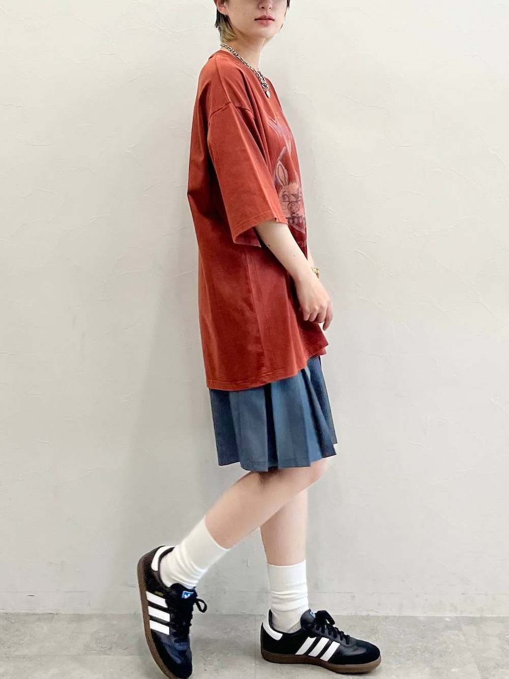 グレー系のその他パンツ、ブラック系のスニーカー、レッド系のTシャツ/カットソーを着用したレディースの春コーディネートの6枚目の写真