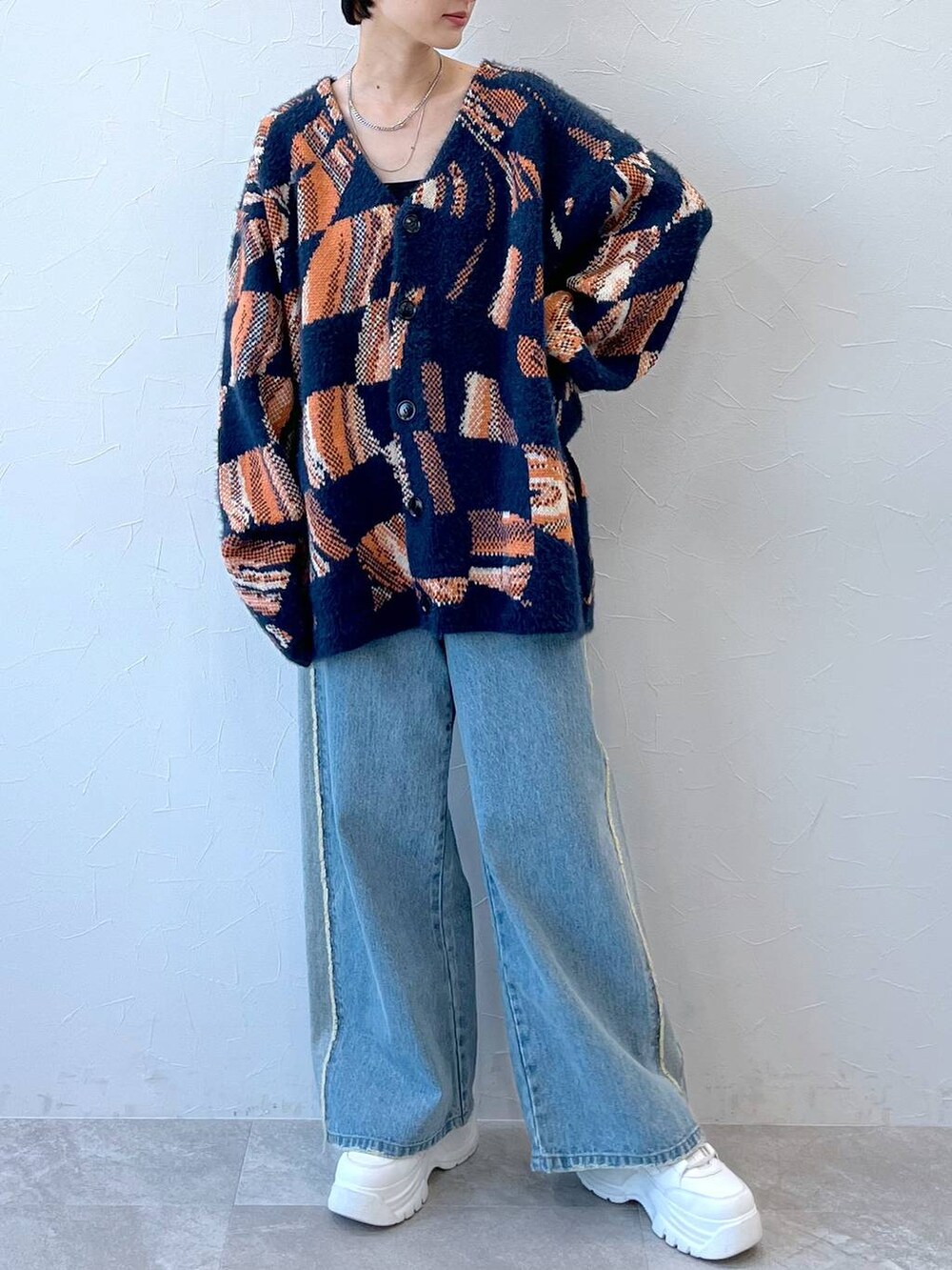 ブルー系のデニムパンツ、ブルー系のニット/セーター、ブラック系のニットキャップ/ビーニーを着用したレディースの秋コーディネートの2枚目の写真