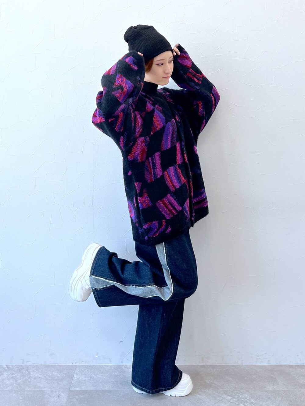 ブルー系のデニムパンツ、ブラック系のニット/セーター、ブラック系のニットキャップ/ビーニーを着用したレディースの秋コーディネートの6枚目の写真