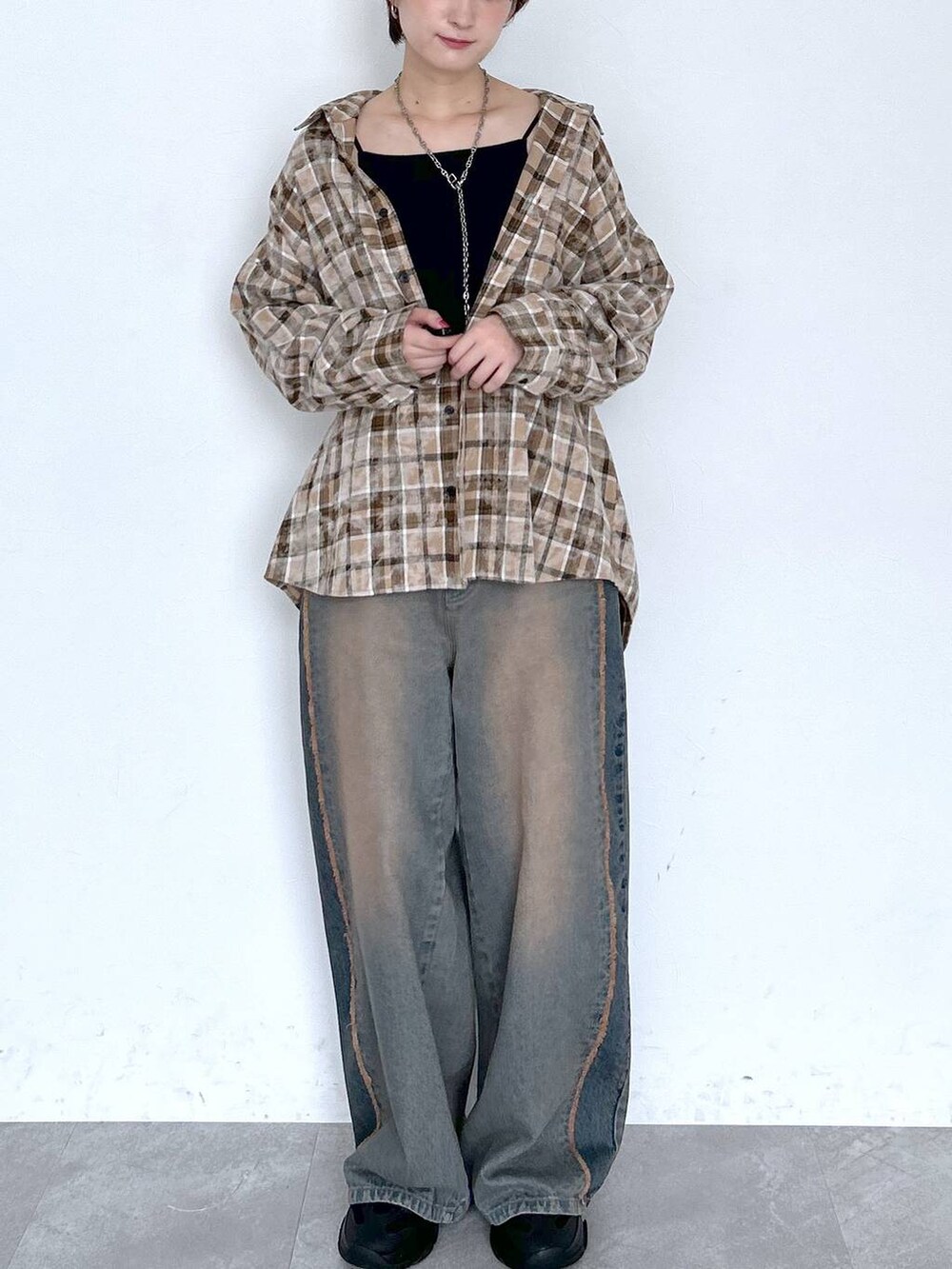 ブルー系のデニムパンツ、ブラウン系のシャツ/ブラウス、ブラック系のベルトを着用したレディースの夏コーディネートの2枚目の写真