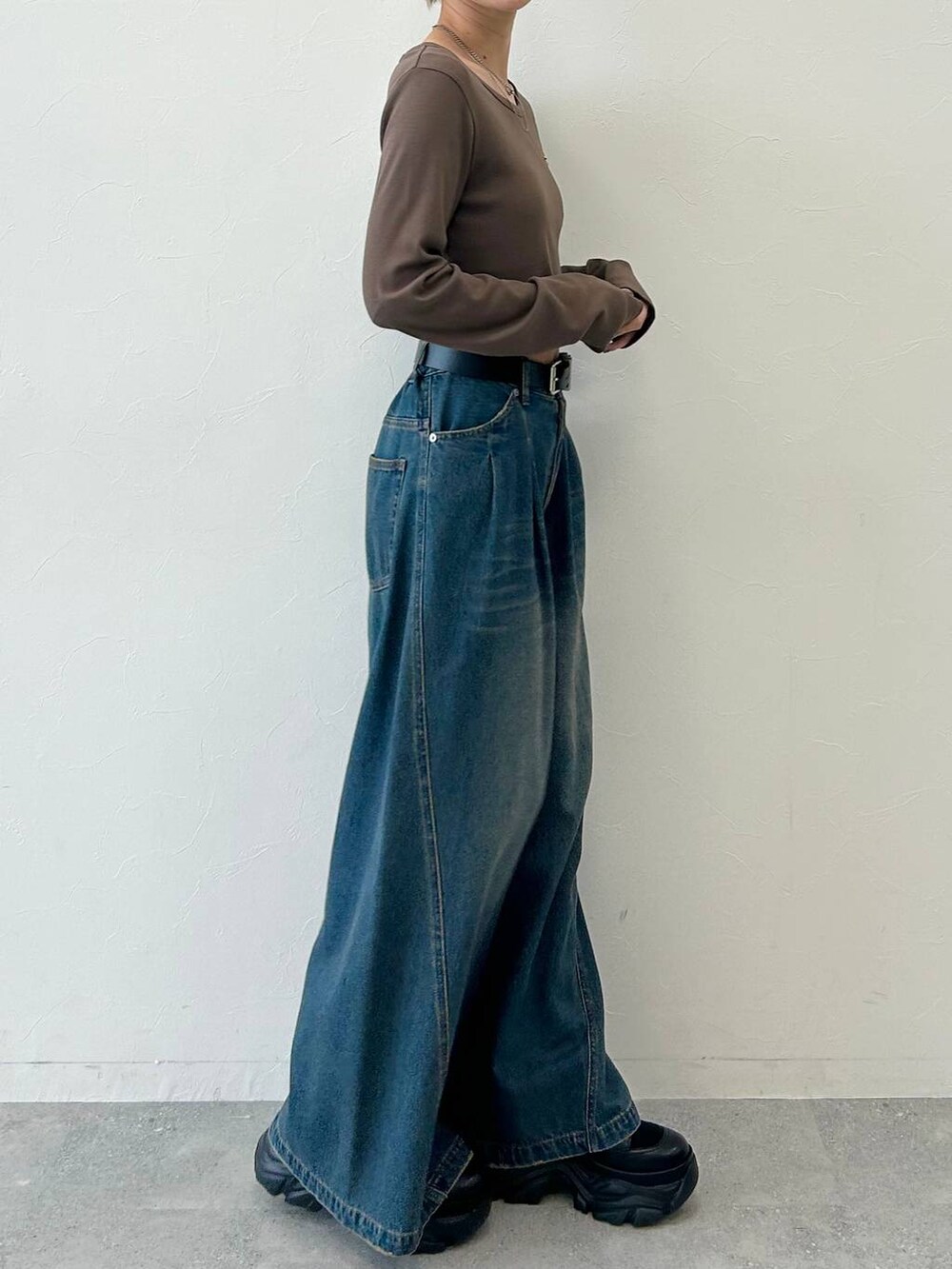 ブラック系のスニーカー、ブルー系のデニムパンツ、ブラウン系のTシャツ/カットソーを着用したレディースの春コーディネートの4枚目の写真