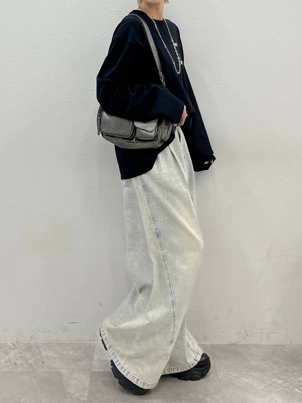 ブラック系のスニーカー、ブルー系のデニムパンツ、その他のショルダーバッグを着用したレディースの春コーディネートの6枚目の写真