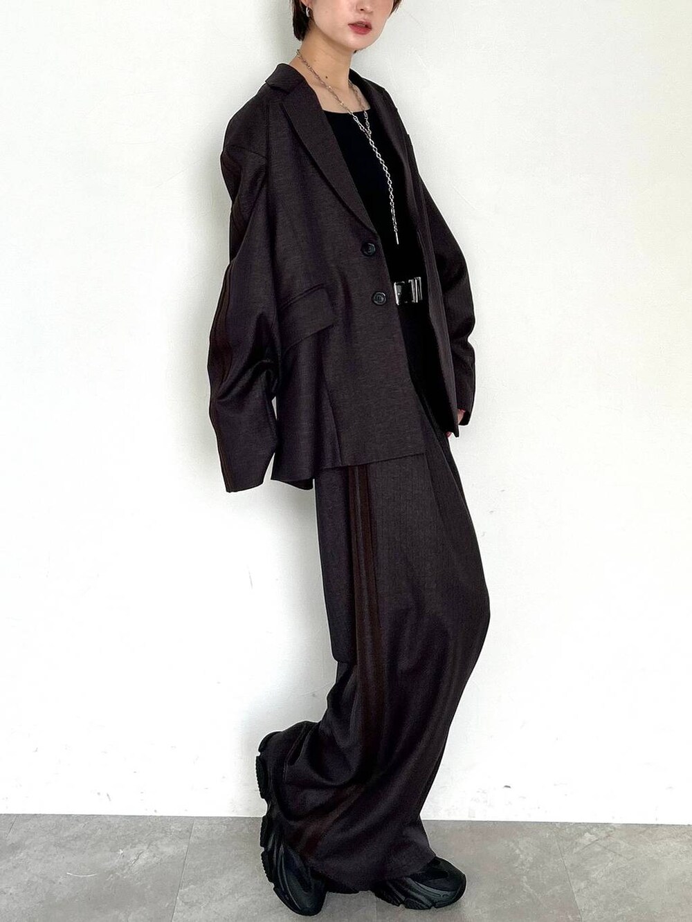 ブラウン系のスラックス、ブラウン系のテーラードジャケット、ブラック系のベルトを着用したレディースの秋コーディネートの5枚目の写真